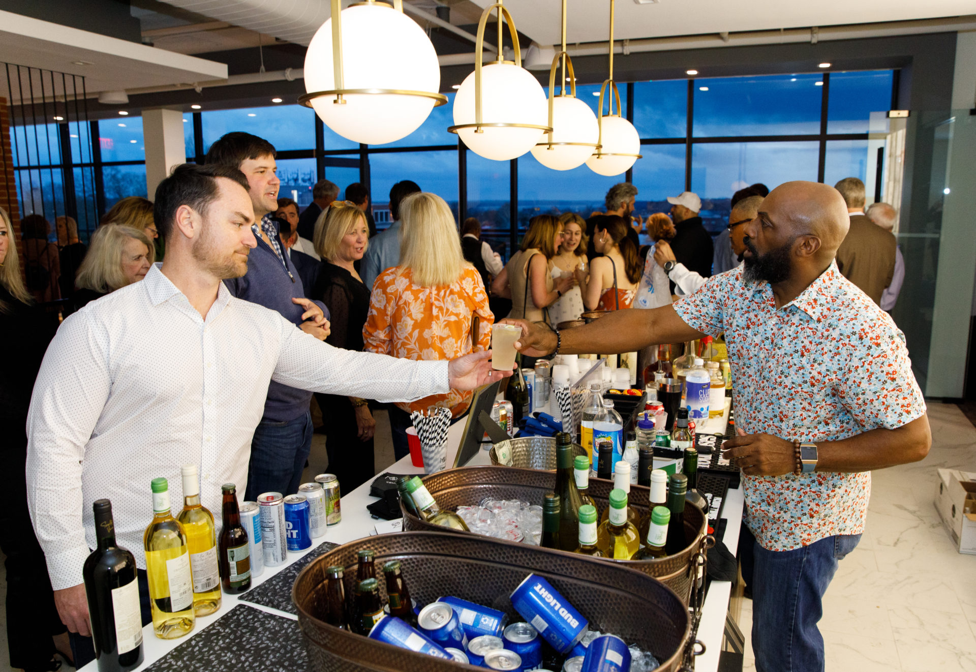 Colleagues enjoy themselves at their company event, toasting over the marble bar at Above.